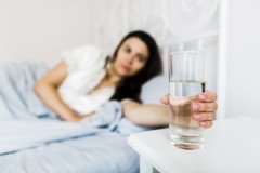 female-bed-holding-glass-water