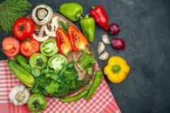 top-view-vegetables-mushrooms-red-green-tomatoes-bell-peppers-greens-rustic-board-red-onions-hot-peppers-garlic-red-white-checkered-tablecloth-black-table_140725-145779