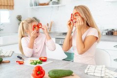 mother-daughter-making-funny-faces-with-peppers_23-2148334853