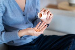 high-angle-woman-holding-pills_23-2149450380